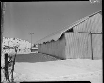 Metal building in desert covered in snow
