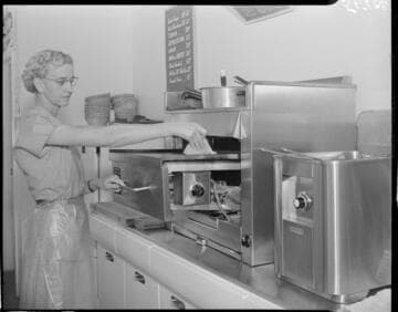 Woman cleaning a grill or oven surface