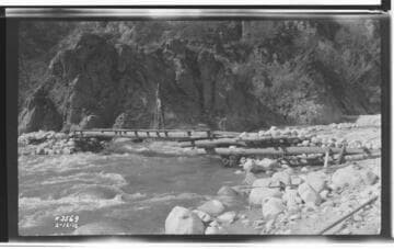 Men constructing Raymaker's Cantilevered Bridge across Santa Ana River after floods