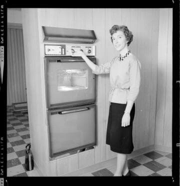 Women demonstrating features of an all-electric kitchen