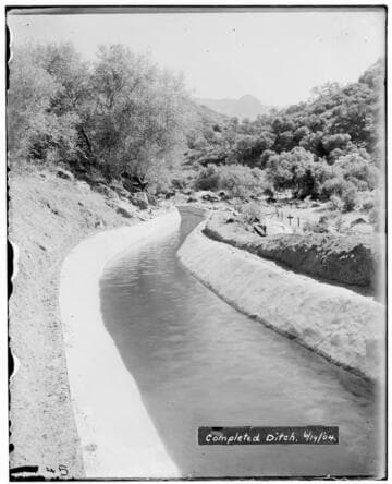 A completed ditch filled with water at Kaweah #2 Hydro Plant showing mountains and trees in the background