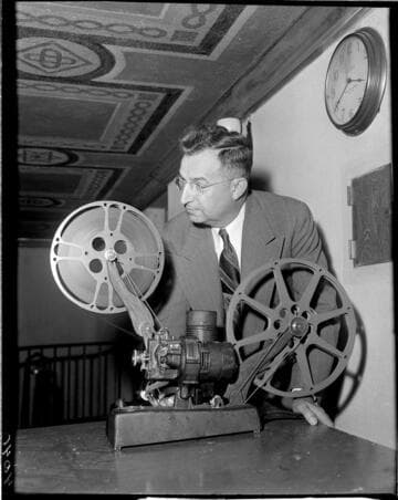 Man running 16mm movie projector