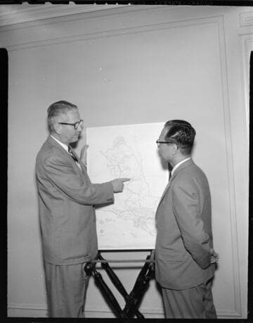 Two men working with a service area map