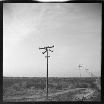 Broken power pole on a double circuit power distribution line running through desert