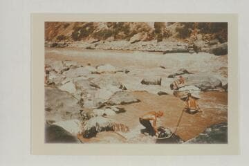 Lining the Nevills sadirons at Vulcan Rapid.  Frost snubs the bow line.  Nevills sits on the skiff.  Desloge is in the water.  Note lack of safety with Frost operating without a life preserver and the other two with the small inflated belts