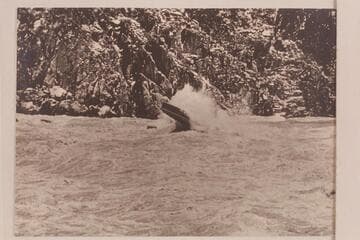 Marston piloting power boat through Granite Falls.  The stage is approximately 53,000 cfs