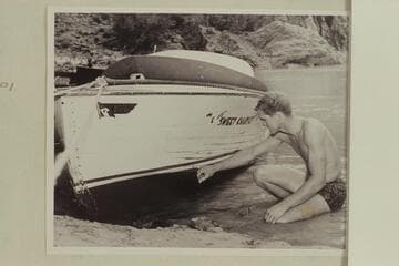 Cooper inspects the damage to the hull of "Sweet Chariot" which occurred in Hance Rapid; Bright Angel Creek
