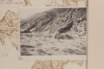 Serpentine Canyon. Les Jones upset on rock above--pushed boat ahead to foot and pushed it by this rock. Jones is on opposite side of rock. 9 AM