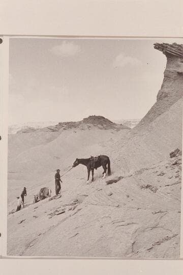 Down the slickrock from the mesa in front of Arch in the Sky at the edge of Navajo Canyon, Arizona.  Left to right:  Tom Daly; Buck White-hat; Bahe