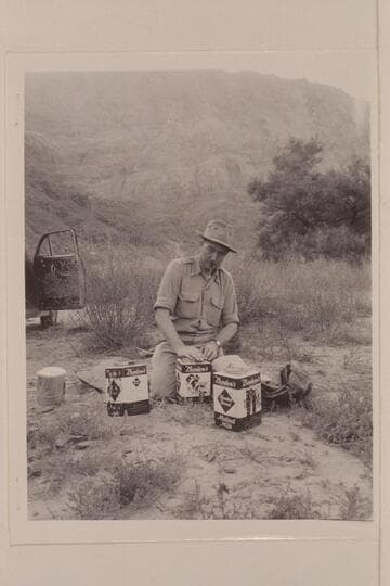 Bestor Robinson stowing food into slip-cover can for the first motor traverse of Grand Canyon