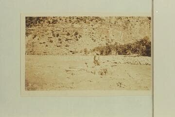 A passenger seeks a dry spot in Chandler Creek Rapid, Desolation Canyon