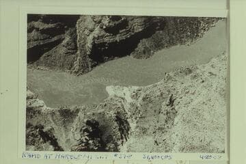 Rapid at mouth of Twenty-two Mile Wash.  The fan is at the mouth of the wash which enters the river at Mile 21.55.  The beach at left is the location of the Stanton camp of July 12-13, 1889