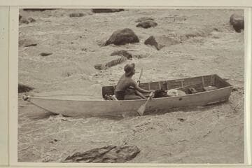 Lorin Bell in Government Rapid, San Juan River.  15-ft. folding spruce boat of the Monument Valley-Rainbow Bridge Expedition borrowed by Nevills