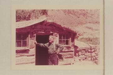 Bert Loper posed by his old cabin in Red Canyon.  Photo by a member of the Scout Troop which Loper guided through Glen Canyon
