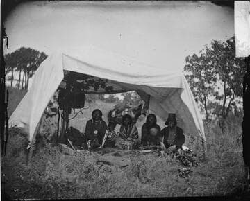 Wolf on the Hill and wife [left] and Little Bear and wife [right]. Cheyennes in camp at Grand Council, Okmulgee 1875