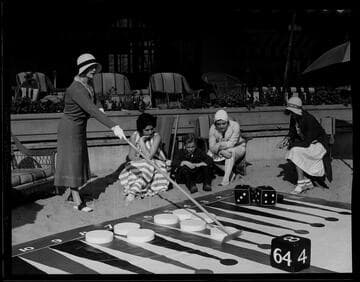 Woman moving giant game piece in giant backgammon game, Santa Monica