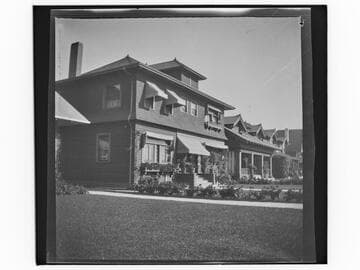 Unidentified houses with lawns and gardens