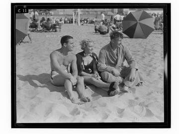 Two men and a woman sitting on the beach, Santa Monica
