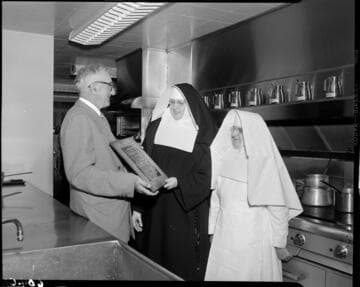 Saint Francis Hospital nuns receiving Merit Award from Institutions Magazine in hospital kitchen