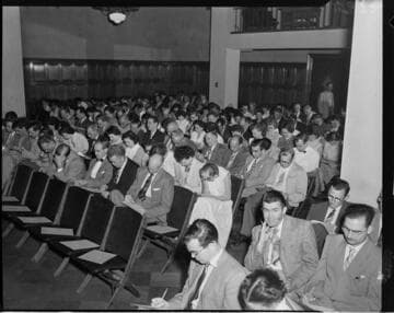 People filling out survey in Edison aduitorium
