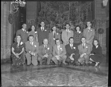 Group of Edison General Office workers in front of the Christmas tree in Edison lobby