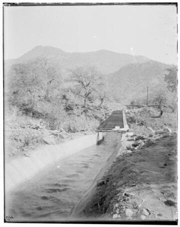 Junction of Kaweah canal in foreground and a long section of flume flowing into the distance
