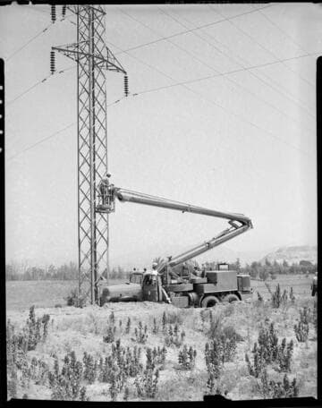 Raising boom at double circuit tower in desert