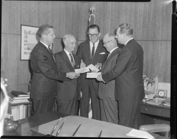 Executives posed exchanging checks