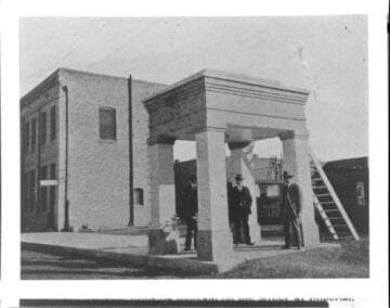 Men standing in brick shelter