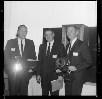 Men presenting Gold Medallion, Total Electric awards to other men