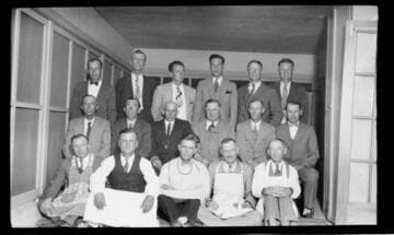 Group shot of 17 men in shirts and ties