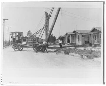 A city crew sets a pole in South Central Los Angeles