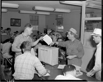 Men placing  "Personnel Survey" forms into ballot box