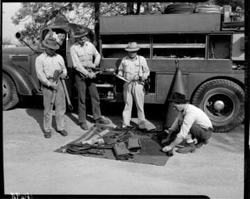 Line crew with tools laid out on tarp beside line truck