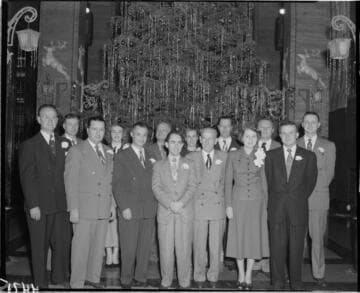 Group of people standing in front of Christmas Tree
