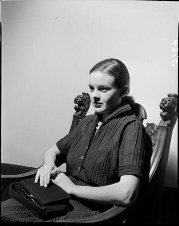 Lady seated in chair against white backdrop