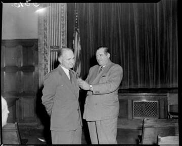 Man receiving service pin from another at the GO auditorium