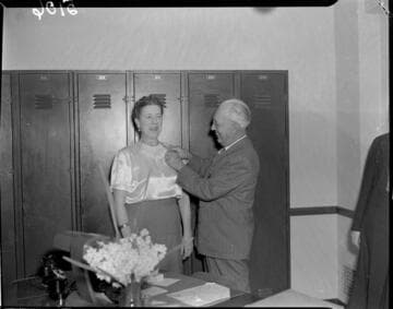 Man pinning service pin to womans blouse