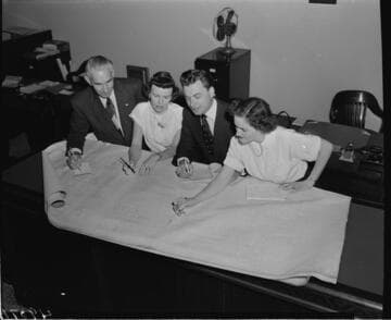 Two men and two women looking at plans