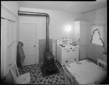 Home kitchen with gas & wood-burning stove, and old technology washing machine