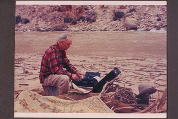 Randall Henderson typing his notes during his traverse of the Grand Canyon