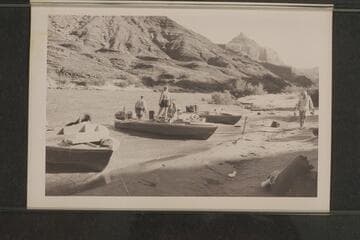Camp below Temple Butte, Grand Canyon, Mile 66.  Rod Sanderson and Dock Marston are in the "Rattlesnake", Garth Marston stands near the boat and Joe Desloge walks on the beach