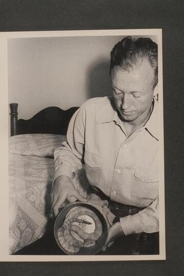 Lorin Bell.  Taken in the Boulder Dam Hotel immediately following the Nevills first Grand Canyon run in 1938.  He exhibits in the can a white rattlesnake which he caught somewhere along the river and kept as a pet for some time thereafter