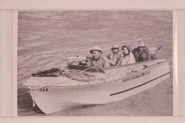 "JAX", the wizard hull owned by Jack Brennan and used on the Yampa and Green River in 1954.  In the boat:  Jack Brennan, Georgiana, Rena and Dr. Leslie White