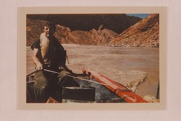 Don Hatch nursing the outboard motor on one of the boloney boats near Hance Rapid.  He holds the line for support