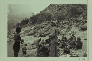 Breakfast above mouth of Prospect Canyon at head of Vulcan Rapid. The Mexican Hat Expedition party; Frank Wright stands in the foreground