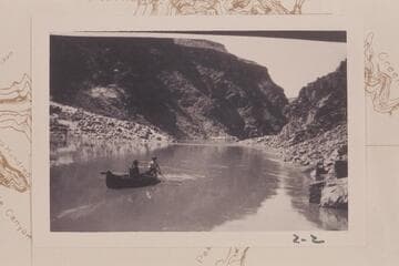 McCuish at the oars and John S. Wilbur steering a folding boat used in prospecting in the lower end of Grand Canyon in the spring of 1904. Taken at Mile 224 1/2. The boat is heading upriver