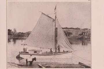 George F. Flavell standing at the mast of the "Examiner" at Yuma